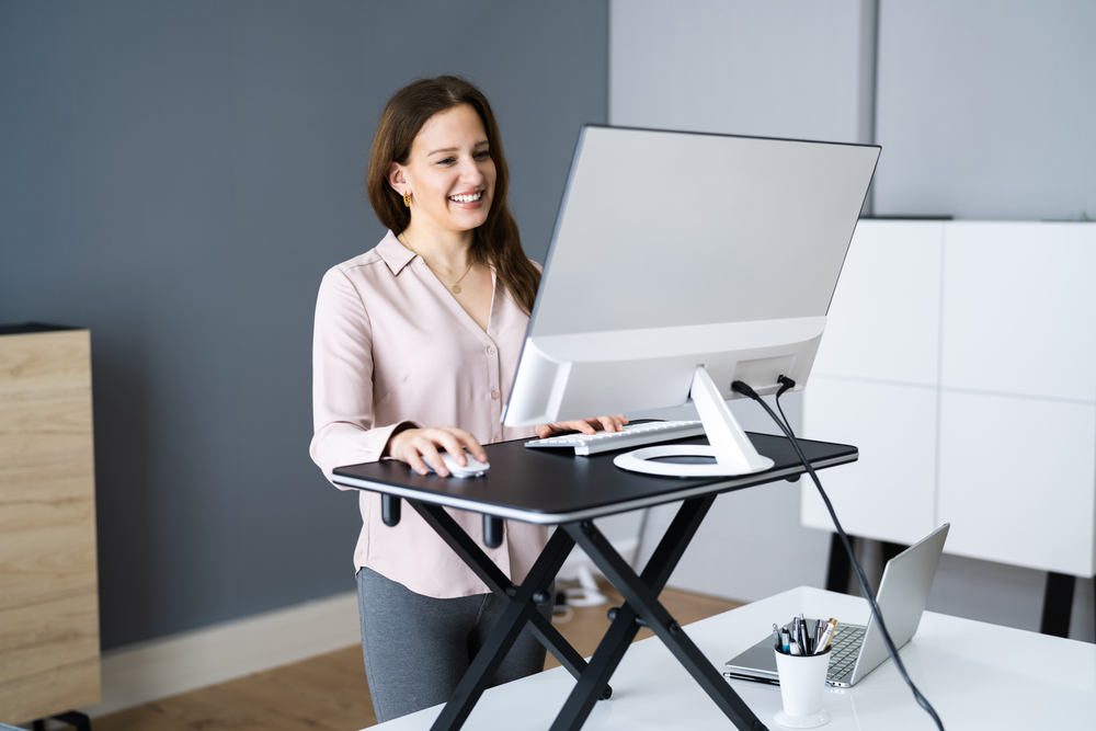 woman using a standing desk in the office